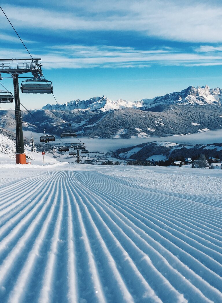 Sessellift über perfekt präparierter Piste in Ski amadé | © Ski amadé GmbH Sessellift über frisch präparierter Piste mit Blick auf verschneite Berge und Tal. | © Ski amadé GmbH